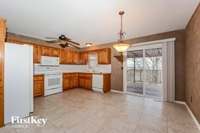 Liberty house for rent - a kitchen with wooden cabinets and white appliances and a sliding glass door
