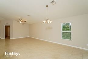 Port St. Lucie house for rent - A spacious room with a ceiling fan and a chandelier.