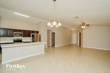 Port St. Lucie house for rent - A spacious kitchen with a white countertop and a microwave built into the cabinetry.