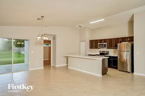 Port St. Lucie house for rent - A kitchen with a refrigerator, microwave, and oven.
