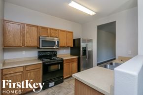 San Tan Valley house for rent - a kitchen with wooden cabinets and black appliances and a stainless steel refrigerator