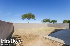 San Tan Valley house for rent - a dirt road with a concrete wall and trees in the background