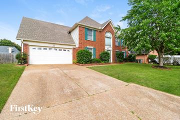 Cordova house for rent - a large driveway in front of a brick house with a white garage door