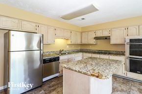 Cordova house for rent - a kitchen with white cabinets and granite counter tops and stainless steel appliances