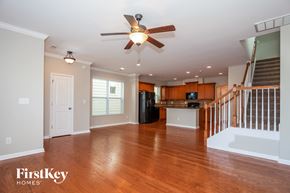 Davidson house for rent - A spacious living room with wood floors and a ceiling fan.
