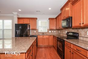 Davidson house for rent - A kitchen with wooden cabinets and a granite countertop.