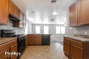 Houston house for rent - a kitchen with wood cabinets and black appliances and tiled floor