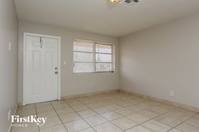 North Lauderdale house for rent - an empty living room with a white door and tiled floors