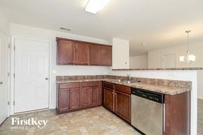 Whitsett house for rent - a kitchen with wooden cabinets and a stainless steel dishwasher