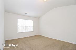 Whitsett house for rent - a bedroom with white walls and carpet and a window