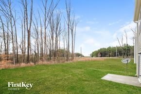 Whitsett house for rent - the backyard of a house with trees and grass