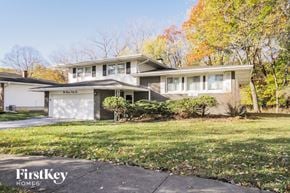 Lansing house for rent - a white brick house with a white garage door
