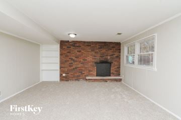 Lansing house for rent - a living room with a brick fireplace and a window