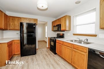 Plainfield house for rent - a kitchen with black appliances and wooden cabinets