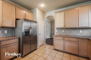 Spring house for rent - A kitchen with a refrigerator and wooden cabinets.