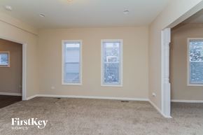 Zion house for rent - a empty room with three windows and a carpeted floor