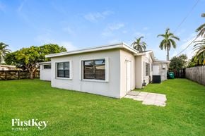 Cutler Bay house for rent - a white house with a lawn and palm trees