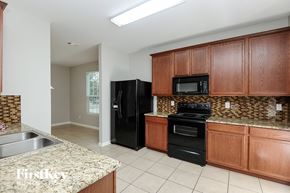Aubrey house for rent - a kitchen with black appliances and granite counter tops