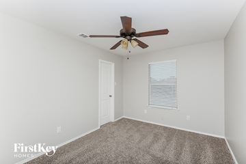 Aubrey house for rent - the living room has a ceiling fan and carpet