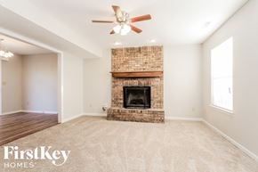 Noblesville house for rent - a living room with a brick fireplace and a ceiling fan