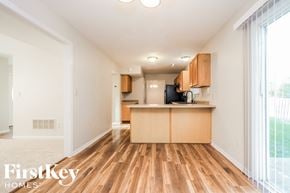 Noblesville house for rent - the living room and kitchen of an apartment with wood flooring and a large window