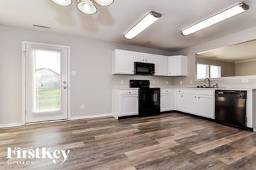 Greenfield house for rent - A kitchen with wooden floors and white cabinets.