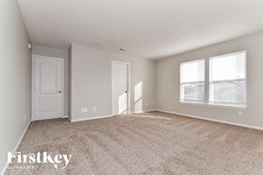 Greenfield house for rent - A spacious room with a carpeted floor and two windows.