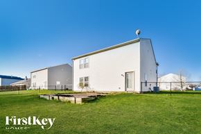 Greenfield house for rent - A house with a white exterior and a grey roof is shown with the text "FirstKey Homes" in the foreground.