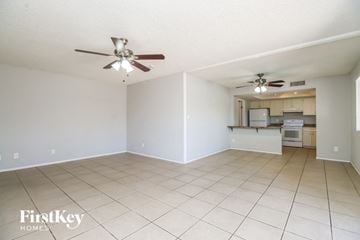 Tempe house for rent - A spacious room with a ceiling fan and a kitchenette in the background.