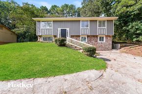 Lithonia house for rent - a small gray house with a lawn and a driveway
