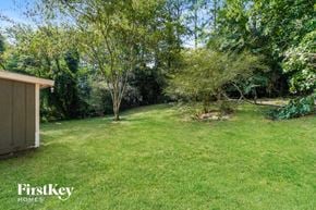 Lithonia house for rent - a backyard with a shed and some trees