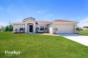 Cape Coral house for rent - A white house with a red roof and a garage door is shown.