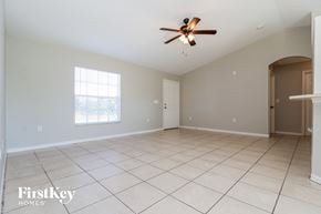 Cape Coral house for rent - A spacious room with a ceiling fan and tiled flooring.