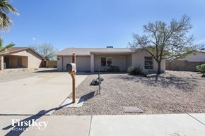 Phoenix house for rent - A house with a gravel driveway and a palm tree in the front yard.