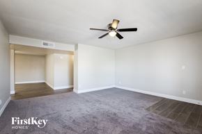 Phoenix house for rent - A spacious room with a ceiling fan and a carpeted floor.