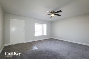 Phoenix house for rent - A spacious room with a ceiling fan and a carpeted floor.
