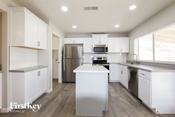 Phoenix house for rent - A modern kitchen with white cabinets and stainless steel appliances.