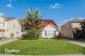 Humble house for rent - A tree in a front yard of a house with a sign that says FirstKey Homes.