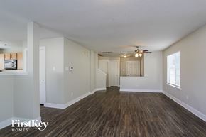 Humble house for rent - A spacious room with wooden flooring and a ceiling fan.