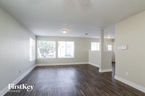 Humble house for rent - A spacious room with wooden floors and a large window.