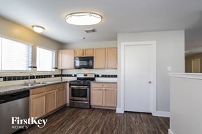 Humble house for rent - A kitchen with wooden cabinets and a black dishwasher.
