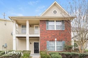 Houston house for rent - a brick house with a balcony and a black door