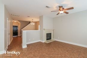 Houston house for rent - a living room with a fireplace and a ceiling fan