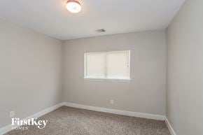 Houston house for rent - a bedroom with white walls and carpet and a window