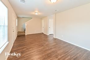 Houston house for rent - A spacious room with wooden flooring and white walls.