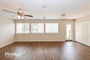Houston house for rent - A spacious room with a ceiling fan and wooden flooring.