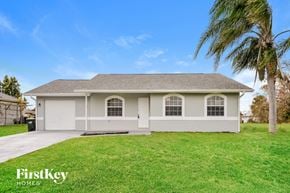 North Port house for rent - a white house with a palm tree in front of it