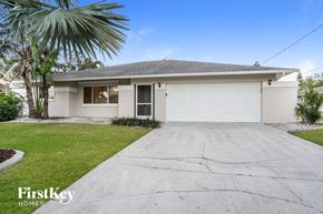 Cape Coral house for rent - a white house with a driveway and a palm tree