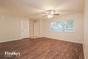 Cape Coral house for rent - an empty living room with a ceiling fan and a window