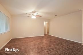 Cape Coral house for rent - an empty living room with a ceiling fan and a window